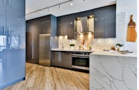 a kitchen with grey cabinets and wood floors