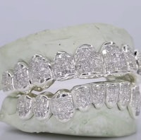a pair of white diamond grills on a white background
