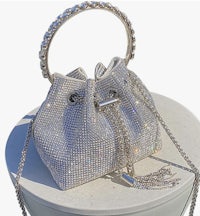 a silver bucket bag with a chain on top