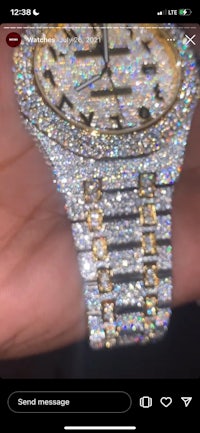 a person is holding a watch with diamonds on it