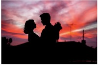 a silhouette of a couple at sunset