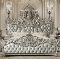 an ornate silver bed with ornate headboard and footboard